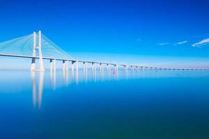Vasco da Gama Bridge mirrored on water, Lisbon, Portugal photo
