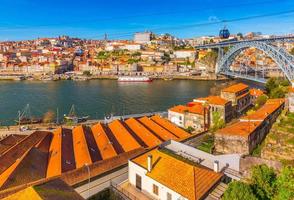 Paisaje urbano de Oporto con el puente Dom Luis I, arquitectura antigua y teleférico, Portugal foto