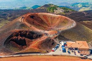 impresionante vista al cráter volcánico y grupos de turistas caminando alrededor de él. Monte Etna, Sicilia, Italia foto