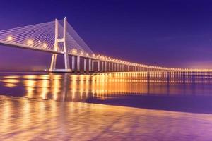 Vista de un moderno puente atirantado en la noche Puente Vasco da Gama, Lisboa, Portugal foto