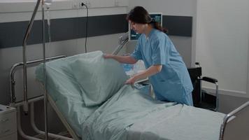 Nurse making bed in hospital ward with healthcare equipment video