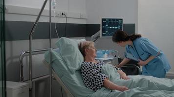 Asistente médico poniendo oxímetro en el dedo del paciente anciano video