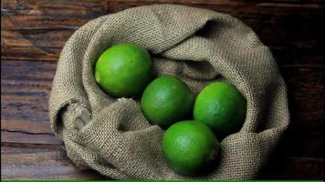 Fresh lemons harvested from plantation and placed in rustic cloth bag on wooden table video