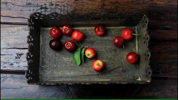 acerolas orgánicas frescas recolectadas de la plantación y colocadas en una caja rústica video