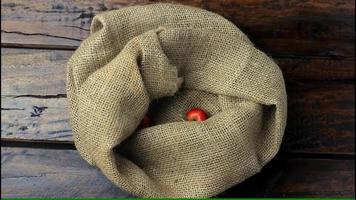 Fresh organic acerolas harvested from the plantation and placed in a rustic cloth bag