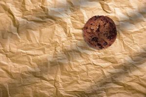 Double chocolate chip cookie on a brown paper, top view. photo