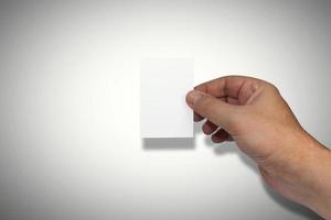 Naturally groomed male hand holding a blank white business card. Room for copy. photo