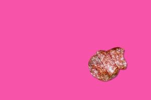 Piece of meat smoked bacon isolated on a pink background. photo