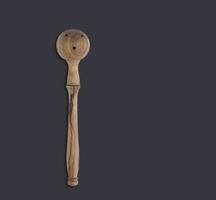 Top up view olive wooden olive spoon isolated on dark background. suitable for your design element. photo