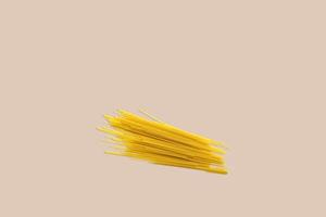 Dry spaghetti on a red background for the menu. Geometric background. Flat lay, copy space, top view. photo