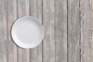 Top up view white plate on dark wooden vintage table . added copy space for text , suitable for your food or drink concept background. photo