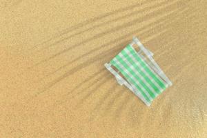 Top up view of green beach chair on sand beach. vacation concept background.