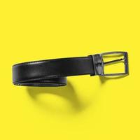 Top up up view black leather belt isolated on yellow background. suitable for your design project. photo