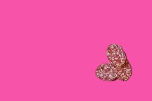 Piece of meat smoked bacon isolated on a pink background. photo