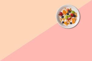 Close up view various fruits soup with milk isolated on pink background. photo