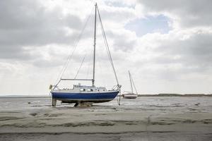 Barcos de pescadores atrapados en la playa en período de marea baja. foto