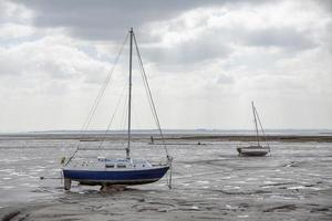 Fisherman boats stuck on the beach in low tide period. photo