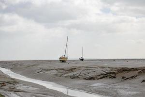 Barcos de pescadores atrapados en la playa en período de marea baja. foto