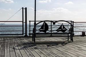 Metal Bench in Front of a Sea or Lake. photo