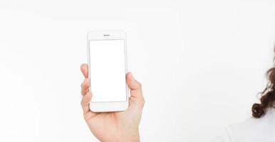 Hand holding white phone isolated on white clipping path inside. Top view.Mock up.Copy space.Template.Blank. photo