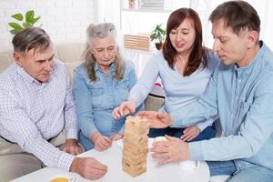 Family gathers wooden pyramid together at table at home photo