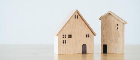 casa de madera en mesa de madera. comprar casa, plan financiero concepto de préstamo hipotecario. foto