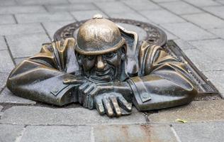 BRATISLAVA, SLOVAKIA, JUNE 16, 2017 - Statue Man at work in Bratislava, Slovakia. This bronze statue of sewer worker was created in 1997 by Viktor Hulik. photo