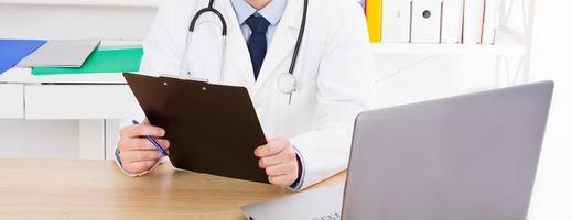 Portrait of senior doctor in medical office.Man in white uniform photo