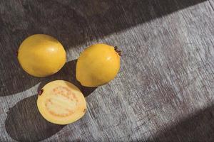 Yellow guava on wooden background. Vitamin C, healthy fruit diet.