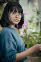 asian teenager take care of orchid flower plant in greenhouse