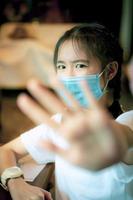 asian teenager wearing protection mask and raising hand