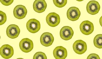 rodajas de kiwi dispuestas en un fondo. patrón de fruta fresca para el diseño de papel tapiz. kiwi fotografiado desde la vista superior. composición de fruta plana foto