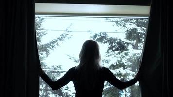 Woman closing window in winter day video