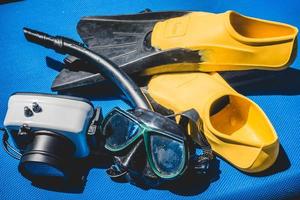 Carcasa de cámara subacuática, aletas, máscara y equipo de buceo en una silla durante un día soleado en el caribe foto