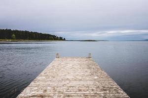 Wooden pier at ocean in cloudy day in Gaspe. photo