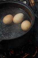 huevos en un caldero lleno de agua hirviendo foto