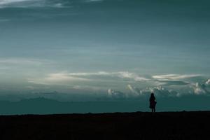 a girl alone on the beach at dusk. A girl is enjoying me time. photo