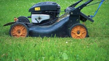 närbild i slow motion av en gräsklippare som klipper gräs video