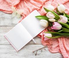cuaderno y tulipanes rosas foto