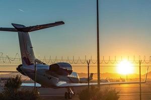 sunrise at the airport with barbed wire security fence and jetlined photo