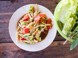 papaya salad and vegetables on wooden floor. photo