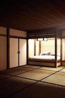El interior de la habitación con cama japonesa tiene lámpara, espada katana y almohada. Representación 3d foto