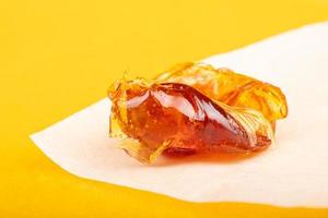 piece of resin cannabis concentrate on yellow background medical marijuana extract photo