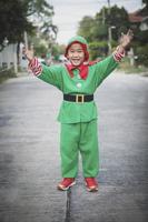 Los niños asiáticos vistiendo traje rojo y verde de santa claus tema exterior permanente foto