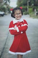 asian girl wearing red suit of santa claus toothy smiling with happiness face