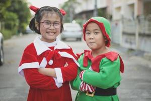 asian girl and boy wearing santa claus suit playing with happiness outdoor photo