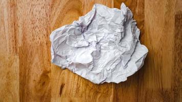 Stop motion animation paper wrinkles making a paper ball and spreads making a blank sheet on wooden background. video