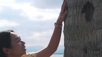 turista feminina tocando um tronco de árvore no parque. o ser humano se preocupa com a natureza e o meio ambiente. video