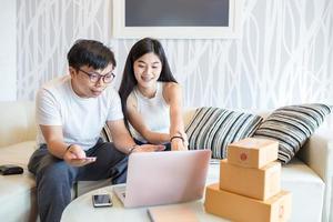 Happy young couple shopping online together at laptop computer and pay with credit card and very happy in apartment of them. This is lifestyles of Asian young. photo