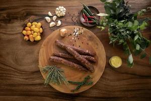 Salchichas de chorizo español sobre mesa de madera rústica con ingredientes naturales foto